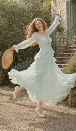 Model twirling in the Celestine’s Waltz mint green chiffon dress outside a romantic French countryside villa