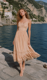 Model wearing the Champagne At Sunset Dress on the Amalfi Coast, featuring a romantic champagne midi dress with lace bodice, flowing skirt, and elegant feminine silhouette.