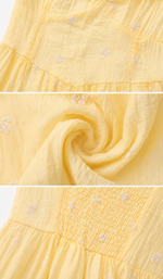 Close-up detail of the Daisies Before Noon Dress featuring embroidered daisy fabric, lightweight texture, and smocked back craftsmanship.