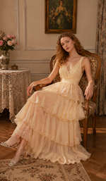 Model seated in the Lilies Before Sunset Dress, showcasing the elegant layered chiffon skirt, delicate floral print, and graceful romantic styling.