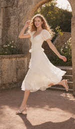 Front view of The Last Promise of Ravello ivory midi dress with puff sleeves and an asymmetric skirt