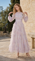 Model twirling in the Violette Butterfly Dress with layered ruffles and metallic gold accents