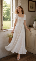 Back view of a white floral puff sleeve maxi dress showing the elegant silhouette and flowing skirt.