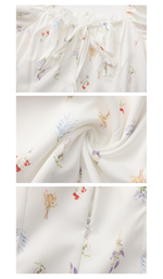 Close-up details of the white floral maxi dress featuring the square neckline, lightweight fabric, floral print, and concealed zipper.